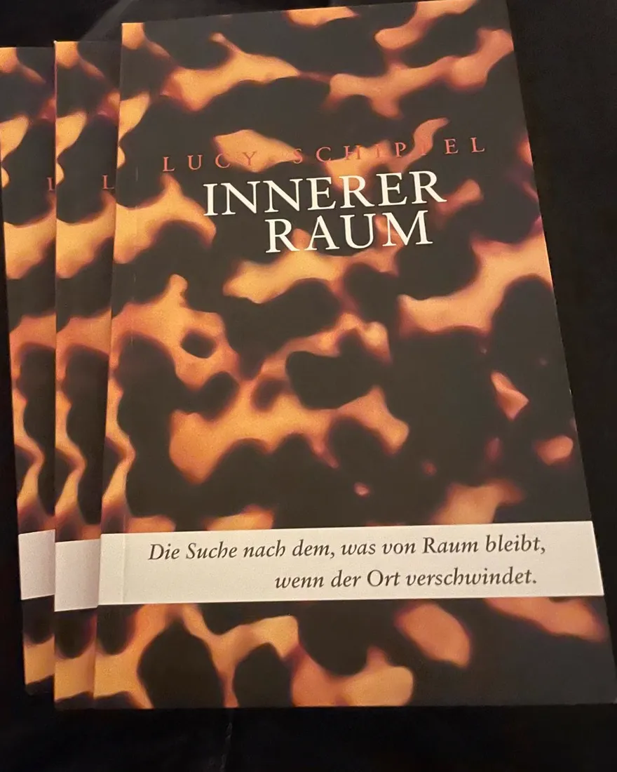 Three printed copies of INNERER RAUM, fanned out. Drei gedruckte Exemplare von INNERER RAUM, aufgefächert.